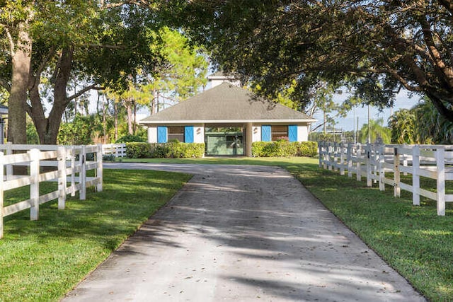 view of front of property featuring fence, a front lawn, and aphalt driveway