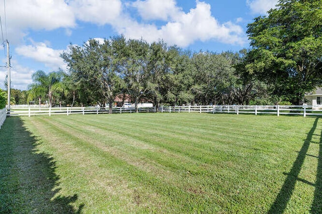view of yard featuring fence and a rural view