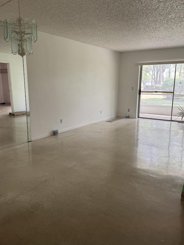 5155 E Sabal Palm Blvd Unit 101, Tamarac, FL 33319 - unfurnished room featuring a textured ceiling, an inviting chandelier, concrete floors, and baseboards