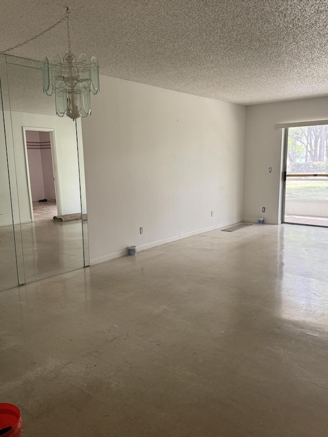 5155 E Sabal Palm Blvd Unit 101, Tamarac, FL 33319 - unfurnished room featuring a textured ceiling, an inviting chandelier, and concrete floors