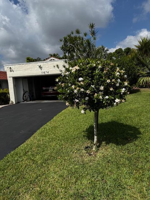 5674 Ainsley Ct, Boynton Beach, FL 33437 - view of front of home with asphalt driveway, a front yard, and an attached garage