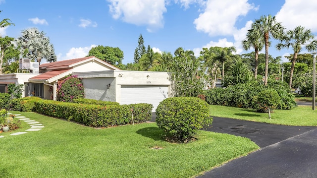 5674 Ainsley Ct, Boynton Beach, FL 33437 - view of front of property featuring an attached garage, stucco siding, a front lawn, asphalt driveway, and a tile roof