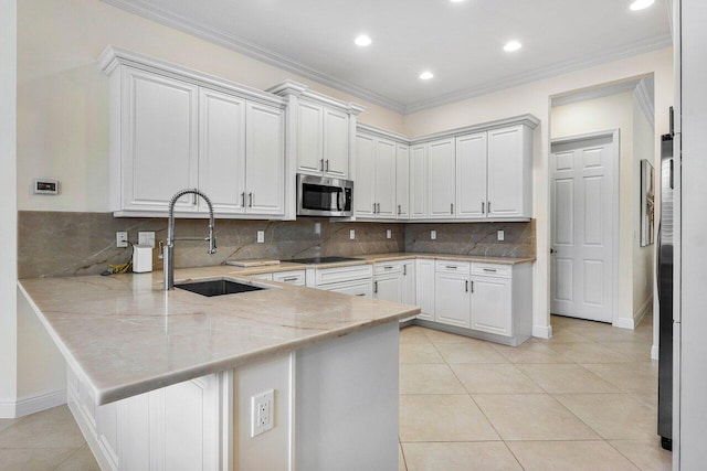 11952 Fox Hill Cir, Boynton Beach, FL 33473 - kitchen with stainless steel microwave, a sink, a peninsula, black electric cooktop, and light stone counters