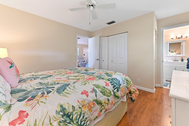 bedroom featuring a sink, light wood-style flooring, baseboards, visible vents, and a closet