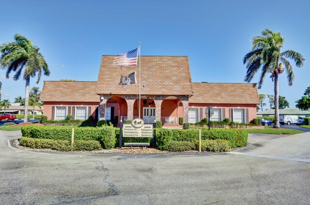 view of front of property featuring roof with shingles and mansard roof