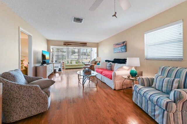 living area featuring visible vents, ceiling fan, and wood finished floors