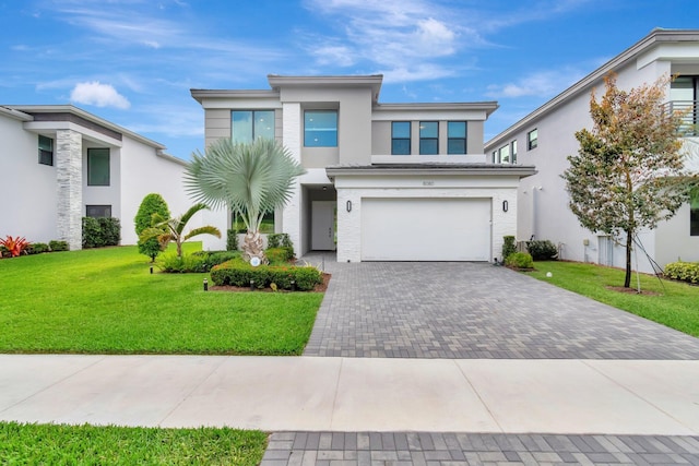view of front of house featuring a garage, stucco siding, decorative driveway, and a front yard