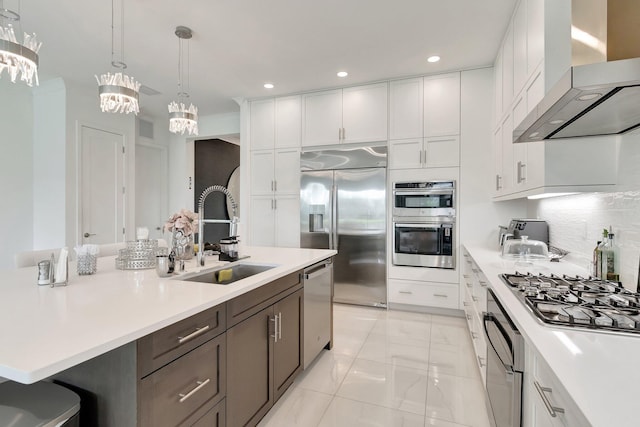 kitchen with a sink, wall chimney exhaust hood, stainless steel appliances, visible vents, and light countertops