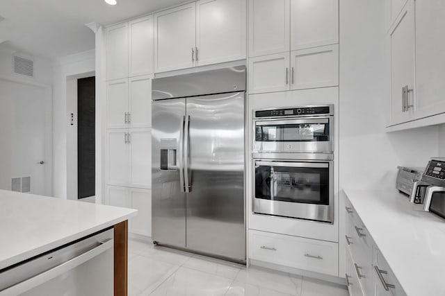 kitchen featuring light countertops, white cabinets, visible vents, and appliances with stainless steel finishes