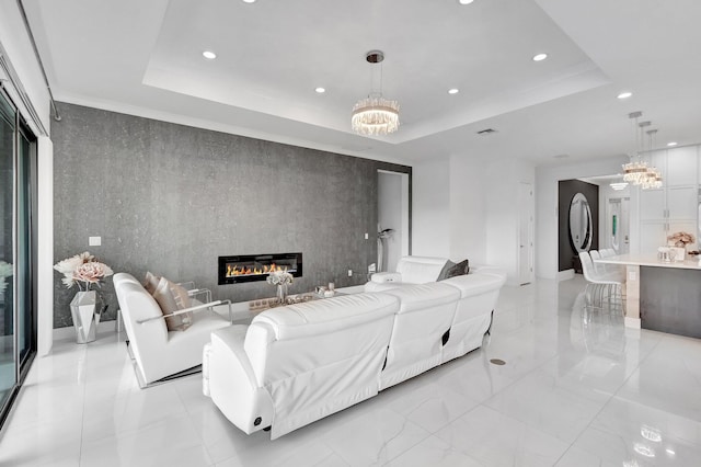living area with a fireplace, a notable chandelier, a raised ceiling, marble finish floor, and recessed lighting