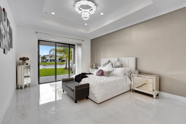 bedroom featuring recessed lighting, baseboards, a water view, a raised ceiling, and access to exterior