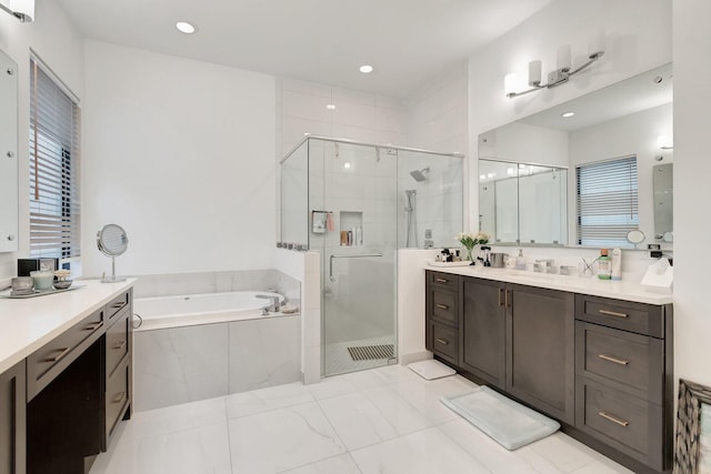 bathroom with a shower stall, a garden tub, vanity, and recessed lighting