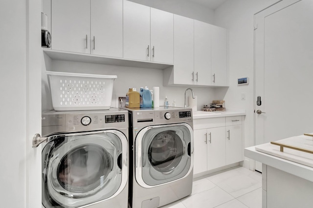 laundry area featuring a sink, cabinet space, light tile patterned floors, and independent washer and dryer