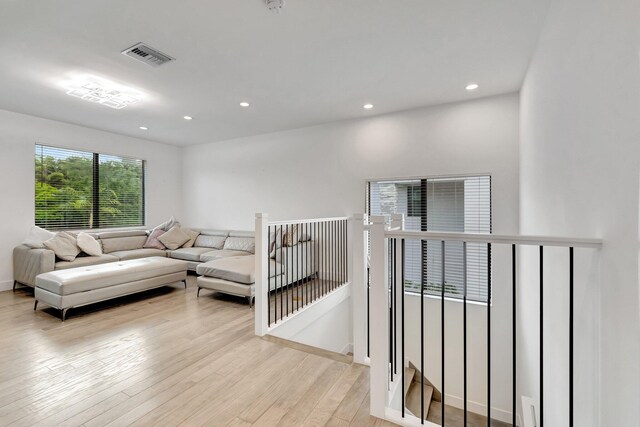 living room featuring light wood-style floors, visible vents, baseboards, and recessed lighting