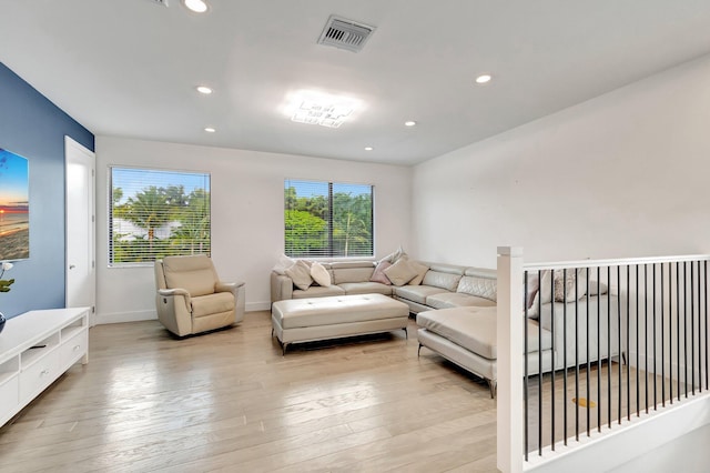 living room with light wood finished floors, visible vents, baseboards, and recessed lighting