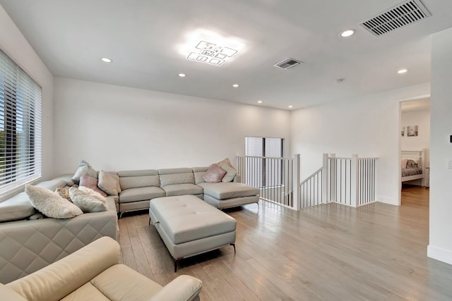 living room featuring light wood finished floors, visible vents, and recessed lighting