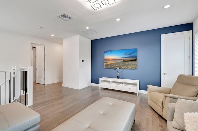 living room featuring recessed lighting, baseboards, visible vents, and wood finished floors