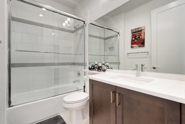 bathroom featuring toilet, vanity, and shower / bath combination with glass door