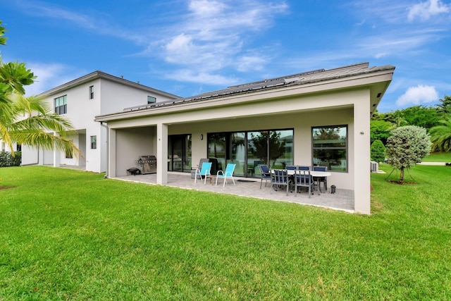 rear view of house with a yard, a patio area, and stucco siding