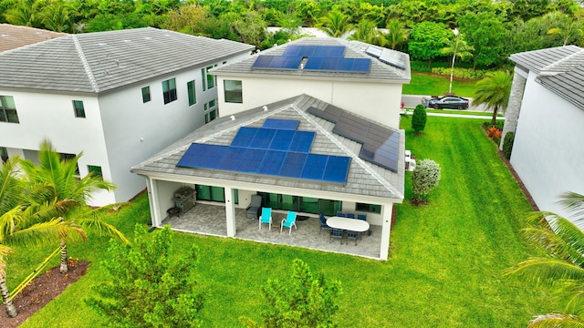 back of property featuring a patio area, solar panels, an outdoor living space, and a lawn