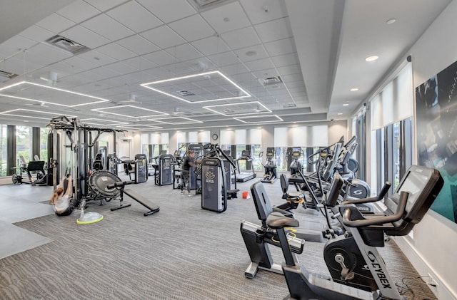 exercise room with a paneled ceiling, visible vents, and carpet