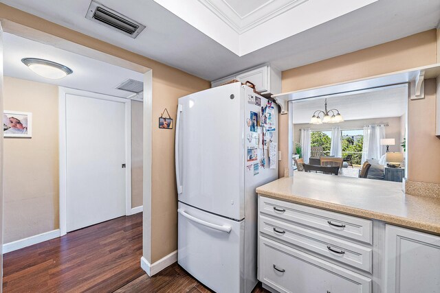 kitchen with freestanding refrigerator, a chandelier, baseboards, and visible vents
