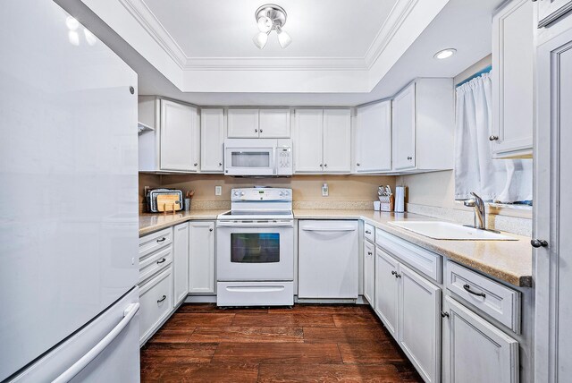 kitchen with crown molding, white appliances, recessed lighting, a tray ceiling, and a sink