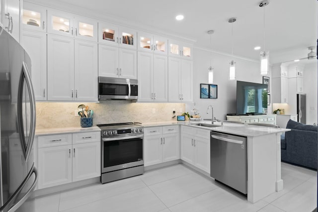 4707 SE Manatee Way, Stuart, FL 34997 - kitchen with a sink, white cabinets, a peninsula, open floor plan, and stainless steel appliances