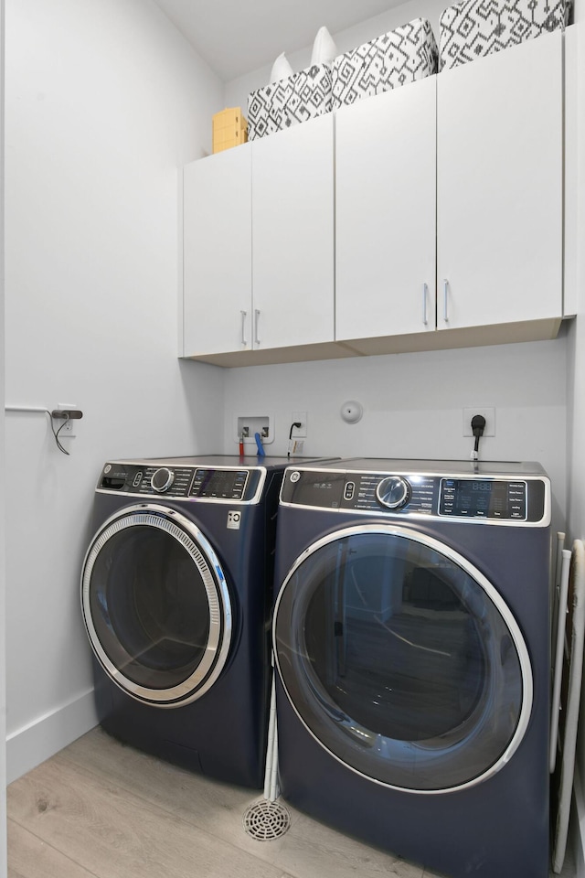 4707 SE Manatee Way, Stuart, FL 34997 - laundry area featuring baseboards, washer and clothes dryer, cabinet space, and wood finished floors
