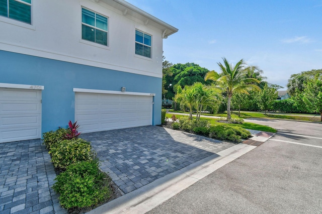 4707 SE Manatee Way, Stuart, FL 34997 - view of property exterior featuring an attached garage, driveway, and stucco siding