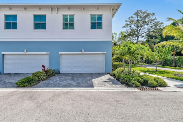 4707 SE Manatee Way, Stuart, FL 34997 - exterior space with an attached garage, stucco siding, and decorative driveway