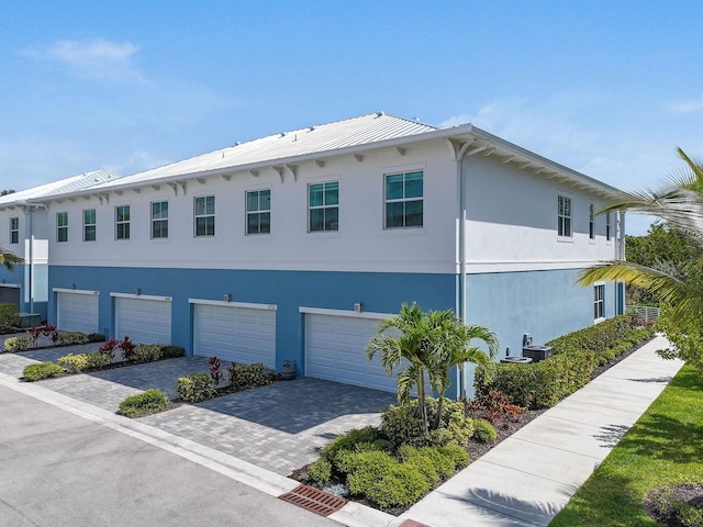 4707 SE Manatee Way, Stuart, FL 34997 - exterior space featuring decorative driveway, an attached garage, and stucco siding