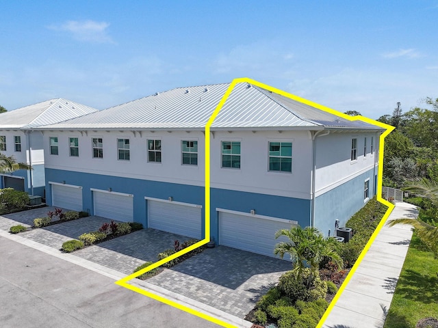 4707 SE Manatee Way, Stuart, FL 34997 - view of front of home featuring an attached garage, stucco siding, a standing seam roof, driveway, and metal roof