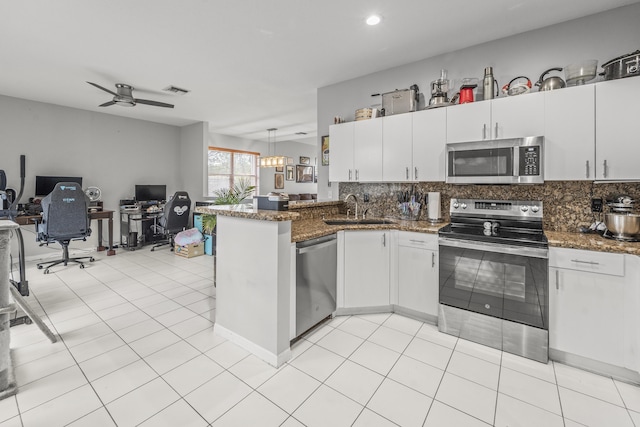 7997 Lakewood Cove Ct, Lake Worth, FL 33467 - kitchen with a sink, stainless steel appliances, open floor plan, a peninsula, and tasteful backsplash