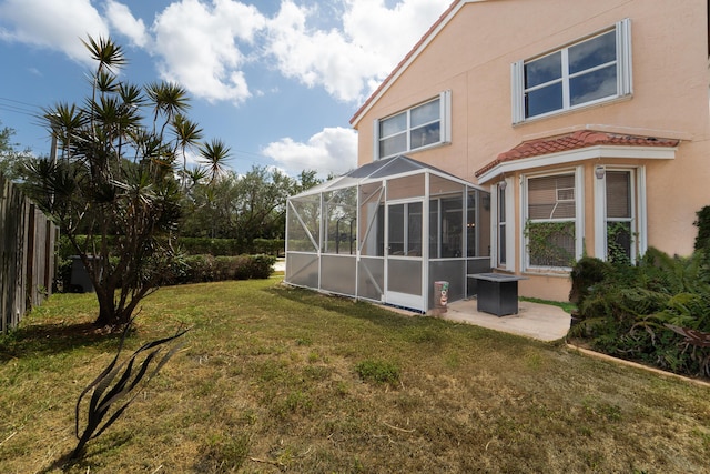 7997 Lakewood Cove Ct, Lake Worth, FL 33467 - rear view of house with glass enclosure, stucco siding, and a yard