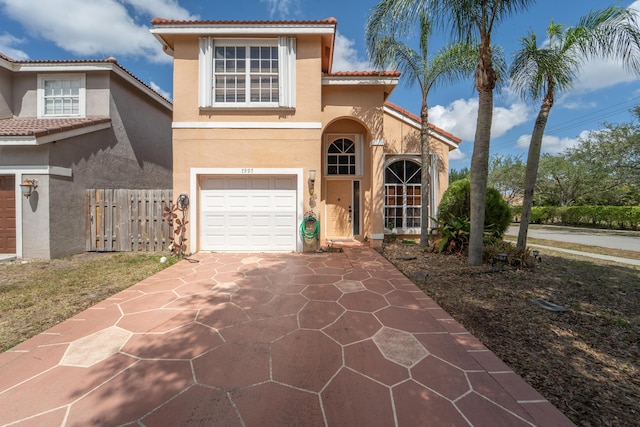 7997 Lakewood Cove Ct, Lake Worth, FL 33467 - mediterranean / spanish-style home featuring driveway, a tile roof, fence, an attached garage, and stucco siding