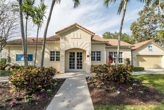 7997 Lakewood Cove Ct, Lake Worth, FL 33467 - view of front facade with french doors, stucco siding, an attached garage, and a tiled roof