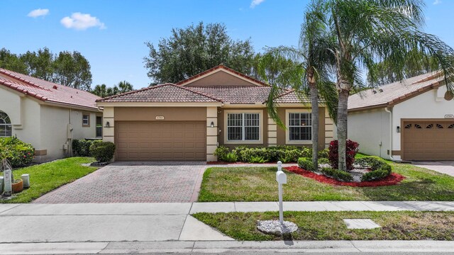 6780 Camille St, Boynton Beach, FL 33437 - mediterranean / spanish house featuring a garage, stucco siding, driveway, and a tiled roof
