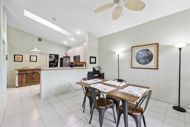 6780 Camille St, Boynton Beach, FL 33437 - dining area featuring visible vents, light tile patterned flooring, baseboards, lofted ceiling with skylight, and ceiling fan