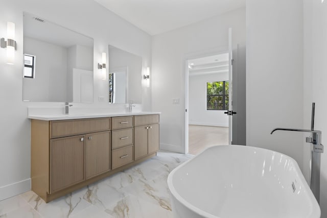 4665 SW Keats St, Port Saint Lucie, FL 34953 - bathroom featuring double vanity, baseboards, a soaking tub, and marble finish flooring