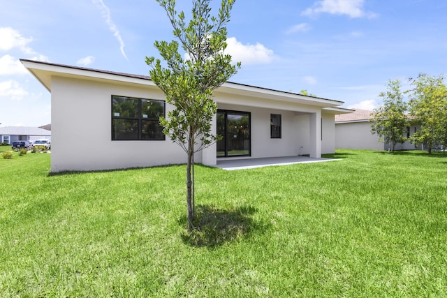 4665 SW Keats St, Port Saint Lucie, FL 34953 - rear view of property featuring a patio, stucco siding, and a lawn