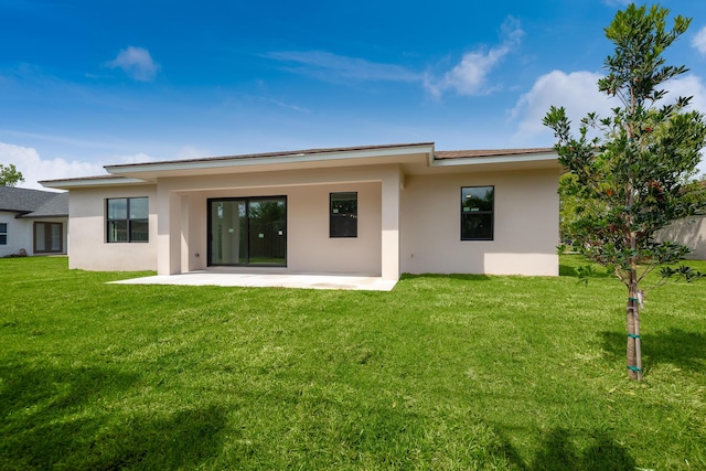4665 SW Keats St, Port Saint Lucie, FL 34953 - rear view of house featuring stucco siding, a patio area, and a lawn