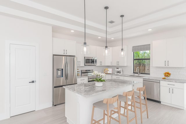 4665 SW Keats St, Port Saint Lucie, FL 34953 - kitchen featuring appliances with stainless steel finishes, recessed lighting, light wood-style floors, decorative backsplash, and white cabinets