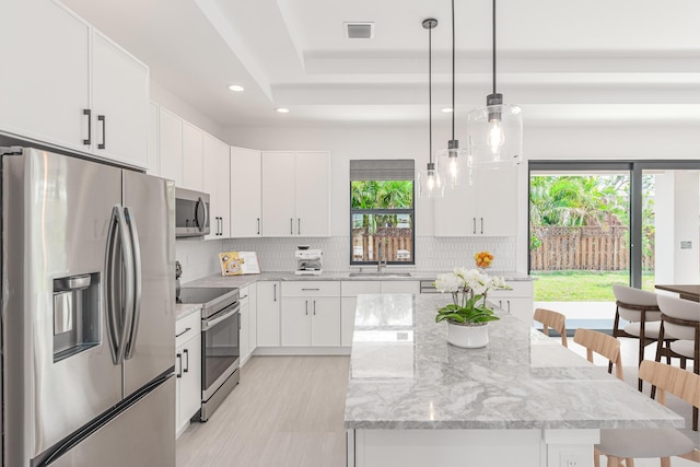 4665 SW Keats St, Port Saint Lucie, FL 34953 - kitchen with stainless steel appliances, healthy amount of natural light, recessed lighting, decorative backsplash, and a kitchen bar