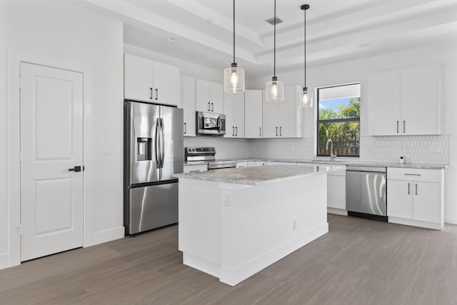 4665 SW Keats St, Port Saint Lucie, FL 34953 - kitchen with appliances with stainless steel finishes, wood finished floors, and backsplash