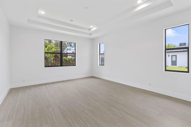 4665 SW Keats St, Port Saint Lucie, FL 34953 - spare room with a tray ceiling, recessed lighting, wood finished floors, and baseboards