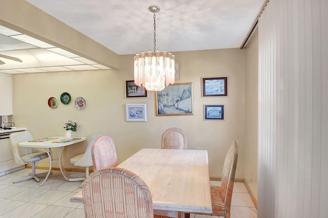 dining area featuring an inviting chandelier, baseboards, and light tile patterned flooring