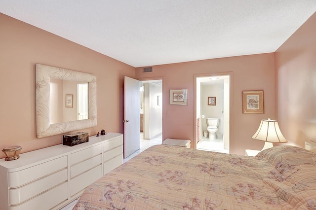 bedroom with visible vents and ensuite bath