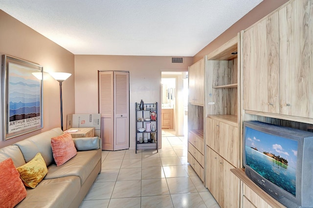 living area with visible vents and light tile patterned floors