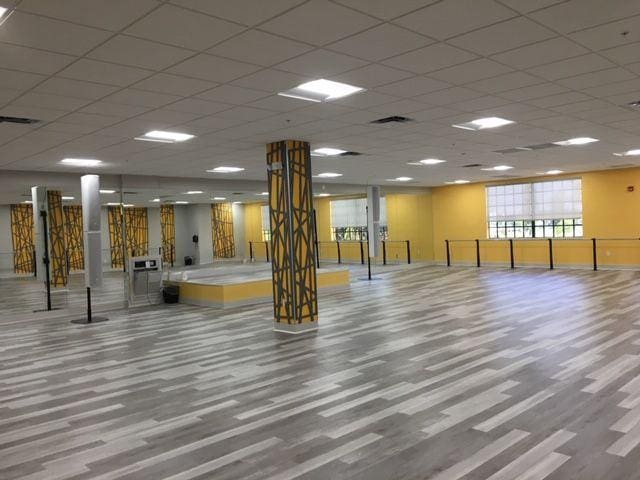 workout room featuring a paneled ceiling, baseboards, visible vents, and wood finished floors